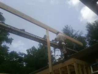 Carpenter setting a ridge beam over a new addition frame — Ice Dam Removal by Roofing Brothers in Donnellson