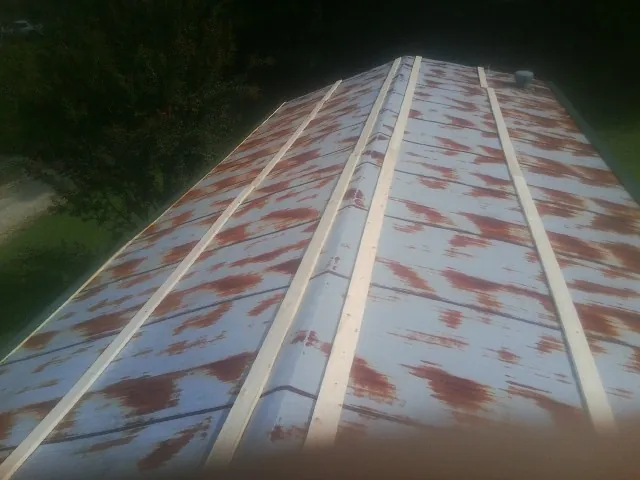 Rusted metal roof panels with new wood purlins before replacement — Storm Damage Roof Repair in Donnellson by Roofing Brothers