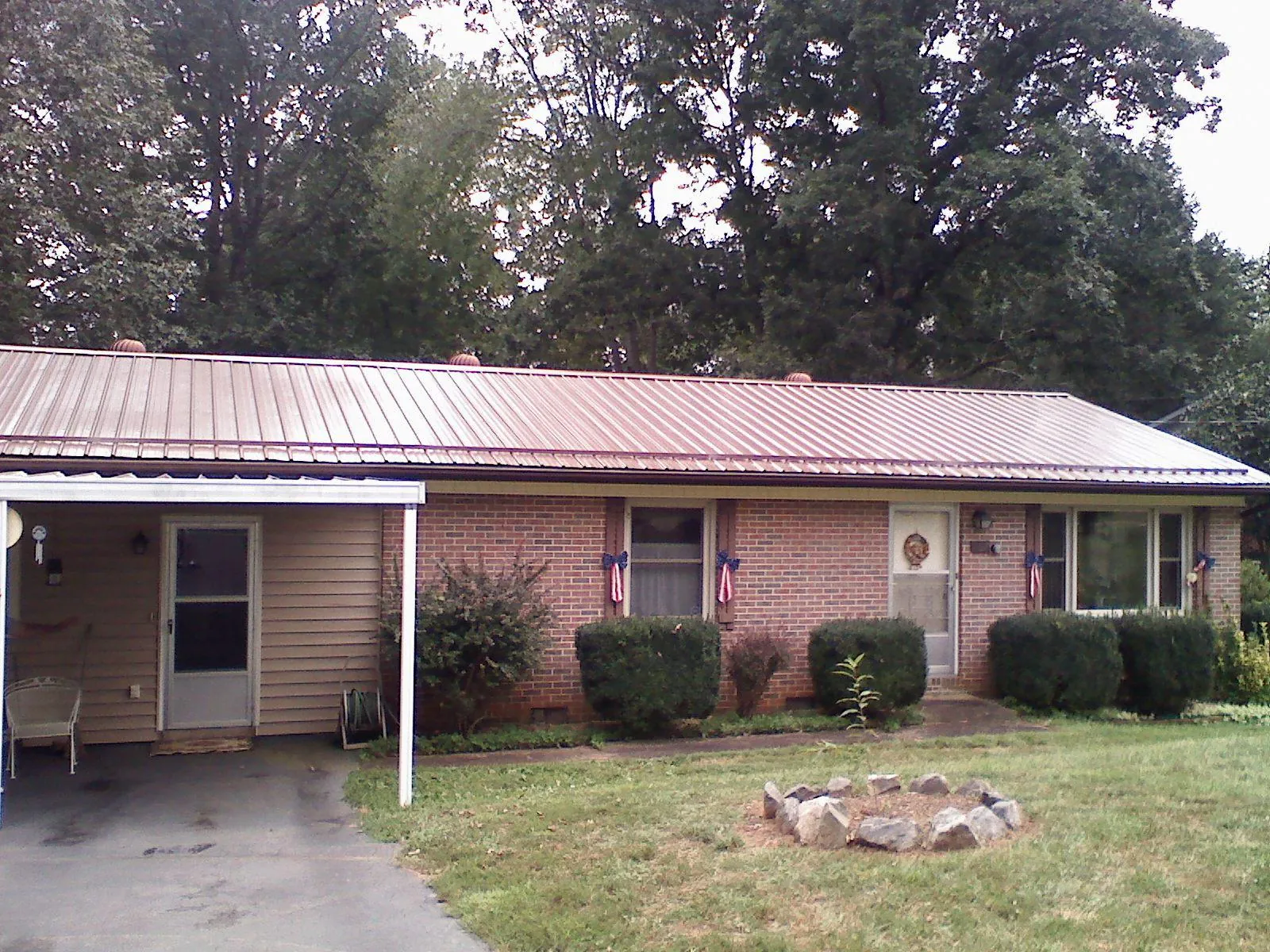 Bronze metal roof and carport on a brick ranch home — Roof Repair work by our crew in Donnellson